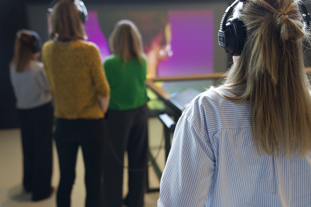 Bezoekers krijgen uitleg over een kunstwerk.