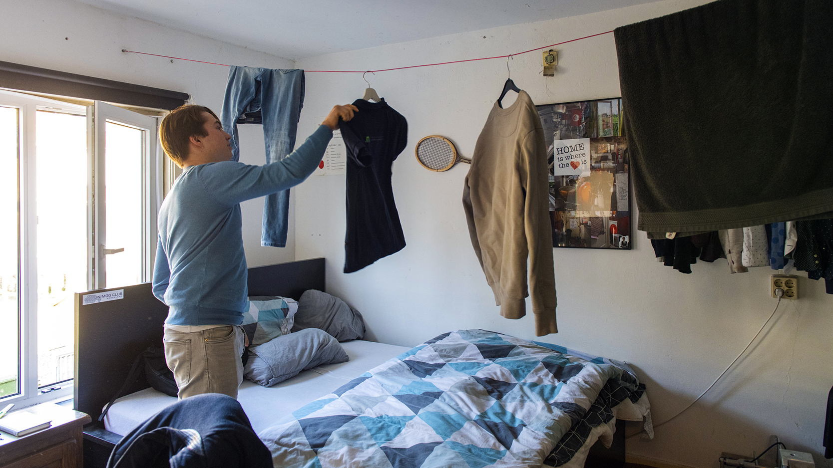 Jongen hangt zijn was op in zijn slaapkamer.