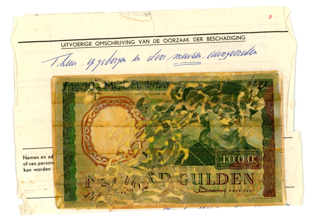©NNC / DNB: Door muizen aangevreten biljet van 1000 gulden, circa 1970. Het biljet werd op karton gemonteerd zodat kon worden vastgesteld welk deel nog aanwezig was en voor vergoeding in aanmerking kwam.